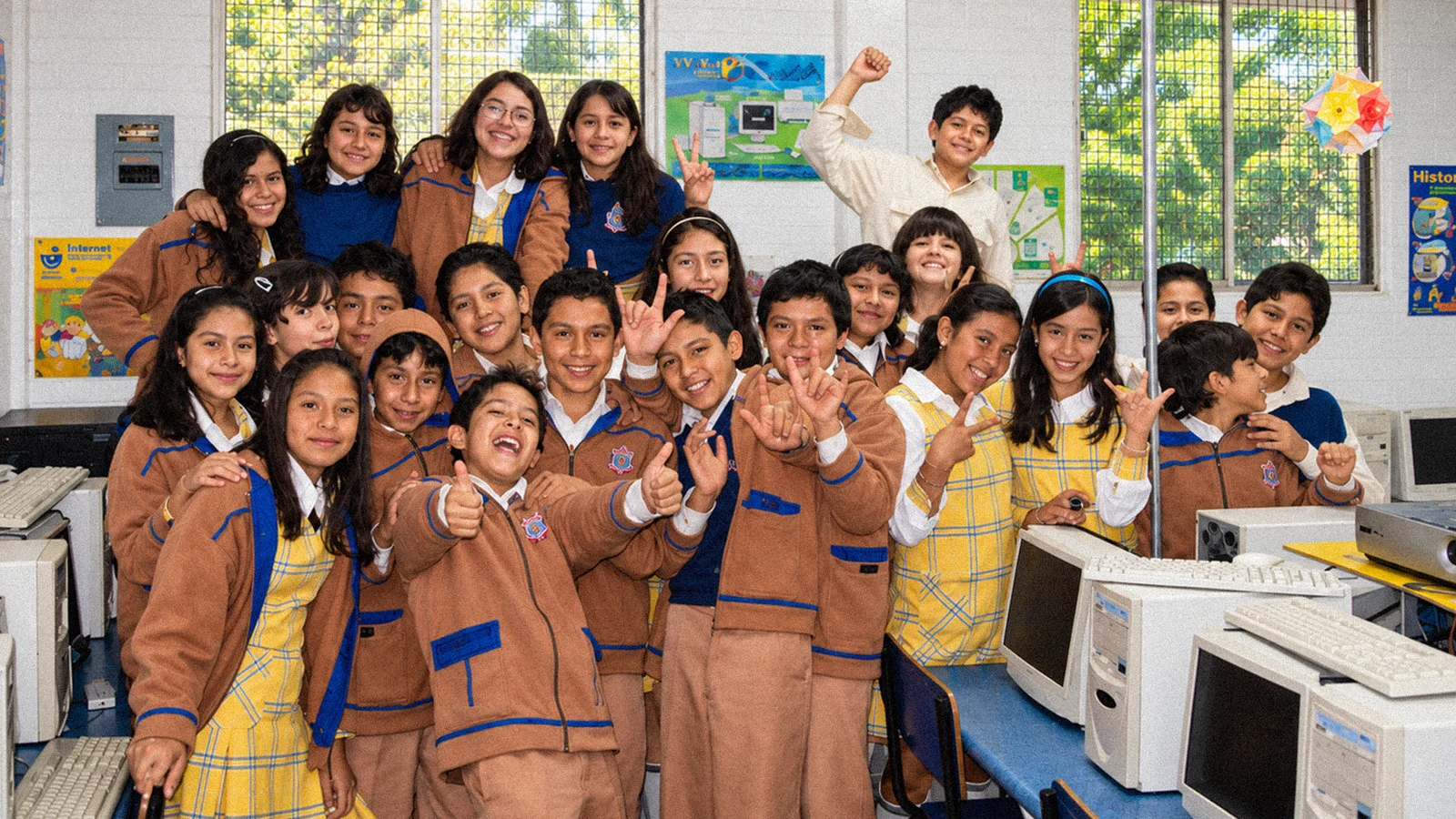 Estudiantes y una adulta posan juntos en un aula de Belmont.